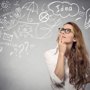 Portrait happy young woman thinking dreaming has many ideas looking up isolated grey wall background. Positive human face expression emotion feeling life perception. Decision making process concept.